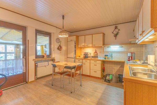 Esszimmer mit offener Küche und Zugang zum überdachten Außenbereich