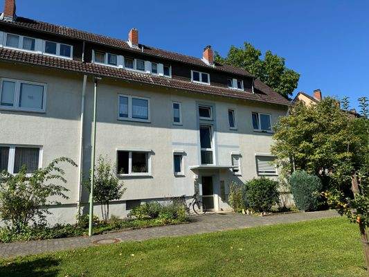 Gebäude Vorderseite des mehrstöckigen Wohnhauses umgeben von Grünanlagen mit Bäumen und Sträuchern