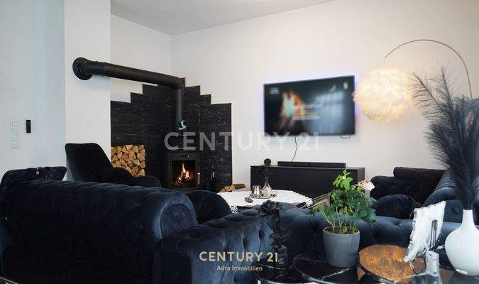 Wohnzimmer mit großem Sofa, viel Licht und Blick ins Grüne