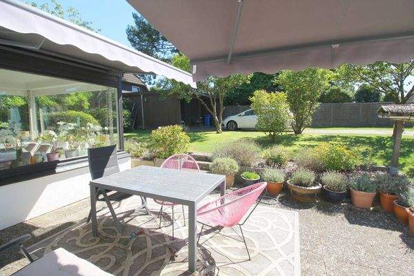 Blick auf Terrasse mit 2 Markisen, Carport u. Wintergarten