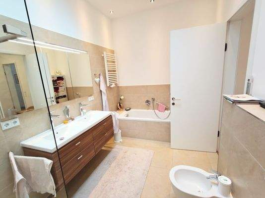 Badezimmer mit bodengleicher Dusche und Wanne