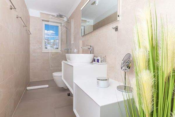 Stilvolles Badezimmer mit hochwertigen Fliesen und bodentiefer Dusche