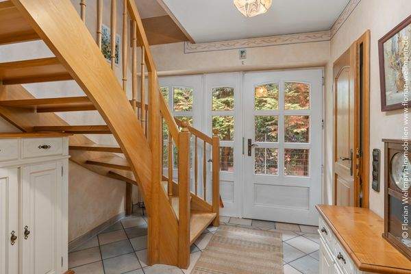 Eingangsdiele (7,25m²) mit freischwebender Holztreppe ins Dachgeschoss.