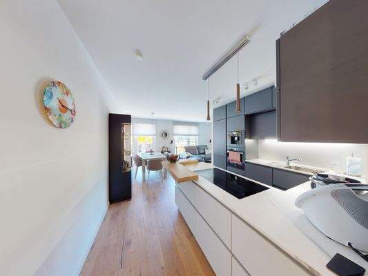 Blick zum Wohn-/ Essbereich mit hochwertiger Einbauküche