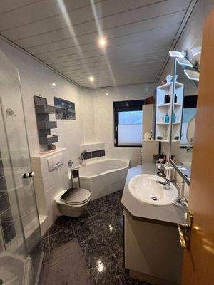 Badezimmer mit Wanne, Dusche und Fenster