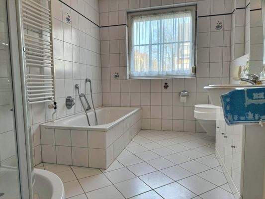 hell gefliestes Tageslichtbad mit Wanne und Dusche