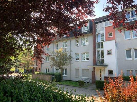 Außenansicht des Mehrfamilienhauses mit Balkonen und Grünflächen 