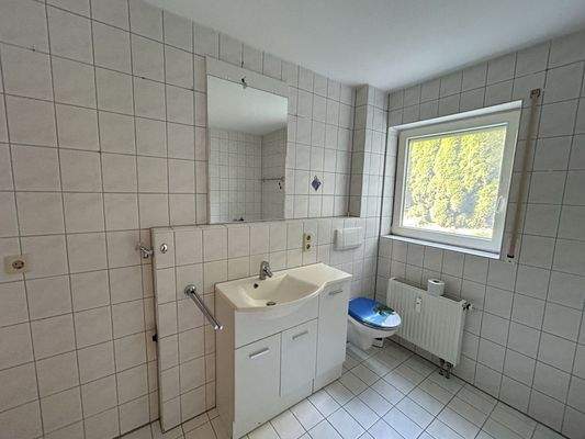 Badezimmer mit Waschmaschinenanschluss, Waschbecken, Badewanne, Dusche und WC