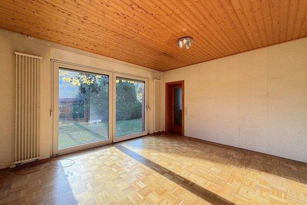 großes Schaufenster mit Blick in den Garten