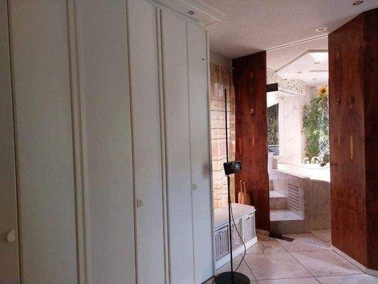 Ankleidezimmer mit Zugang zum Bad