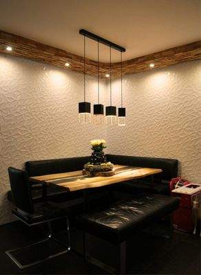 Essbereich mit eleganter Wandgestaltung und Beleuchtung