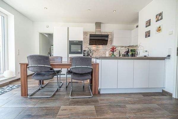 Offene Küche mit viel Tageslicht und Zugang zur Dachterrasse