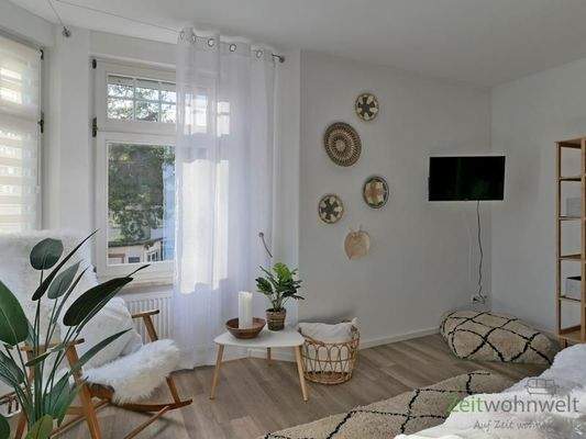 Schaukelstuhl und TV im Schlafzimmer