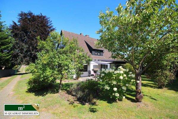 Gartenperspektive auf EFH und großzügige Zufahrt