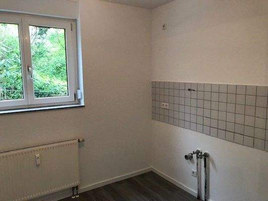 Küche mit Laminatboden und hellem Fliesenspiegel.jpg