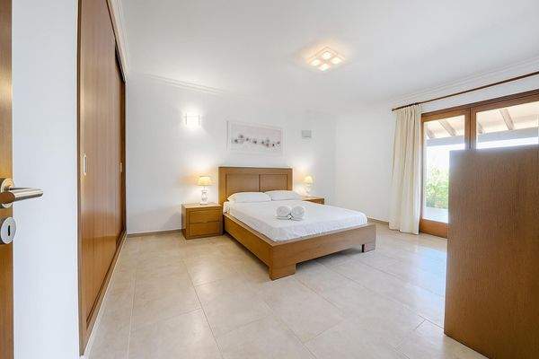 Zweites Schlafzimmer mit Einbauschränken und Zugang zur Terrasse – hell und ruhig.