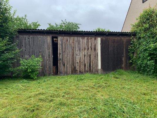 Maschinenschuppen und Holzlege