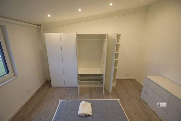 Schlafzimmer mit Bett, Schrank und Kommode