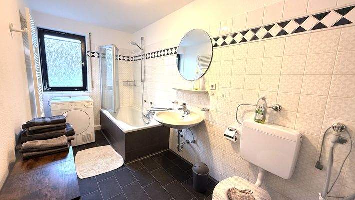 Tageslichtbad mit Badewanne, Waschmaschine und Tro