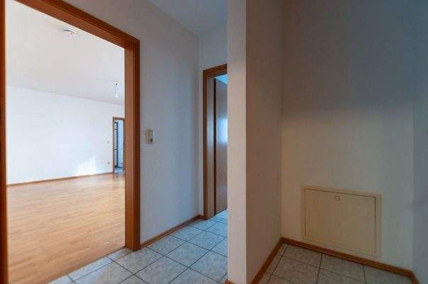 Wohnungstür Blickrichtung Diele mit Abstellecke, Wohnzimmer und Flur Richtung Bad