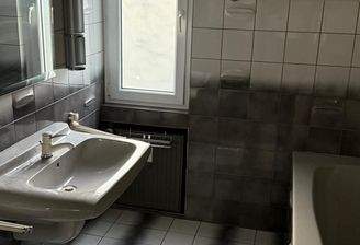 Lichtdurchflutetes Designbad mit praktischer Fensterfront und moderner Sanitärausstattung