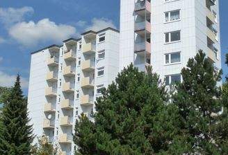 Rückansicht eines mehrstöckigen  Wohngebäudes mit Balkonen, umgeben von Bäumen und grünen  Sträuchern 61df7ead476b9f636ed314823ec0.jpg