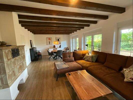 helles Wohnzimmer mit einem Kachelofen