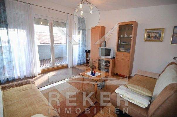 Der helle Wohnbereich verfügt über schöne große Fensterflächen und ienen Durchgang zur Terrasse.