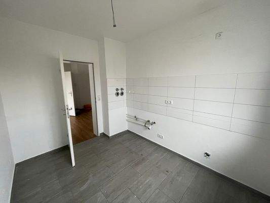 Küche mit Fliesenspiegel, weiß gefliest, grauer Fußboden