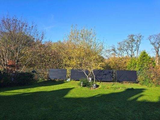 Weitläufige Grünfläche mit Solarpaneelen und Privatsphäre