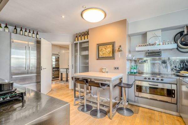 Professionell ausgestattete Edelstahl-Küche mit zentraler Frühstücksinsel und eleganter Linienführung