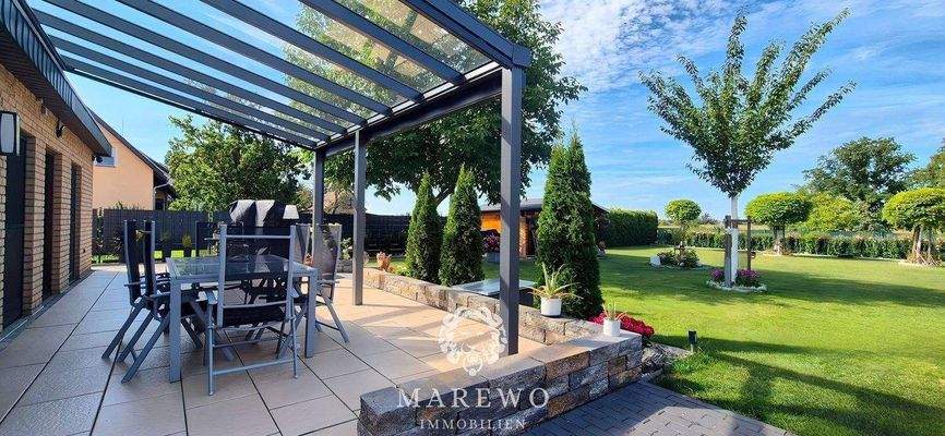 überdachte Terrasse mit Blick auf das Grundstück