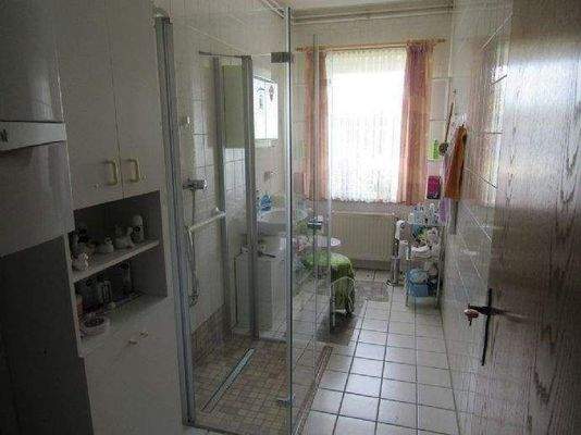 Badezimmer mit Glasdusche und Fenster