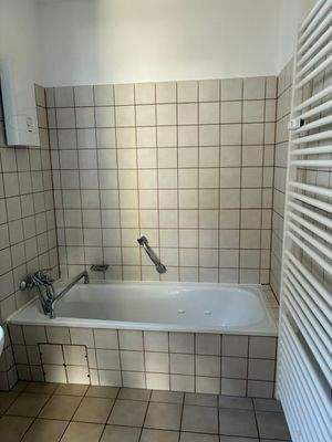 Bad mit Badewanne, Handtuchheizkörper, beigen Wand- und Bodenfliesen