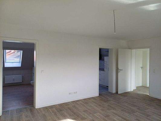 Wohnzimmer mit Zugang Küche/ Bad