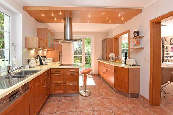 Küche mit Einbauküche, Kochinsel & offener Durchreiche