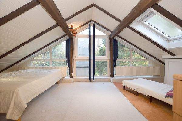 Große Glasflächen mit Gartenblick kennzeichnen dieses Schlafzimmer