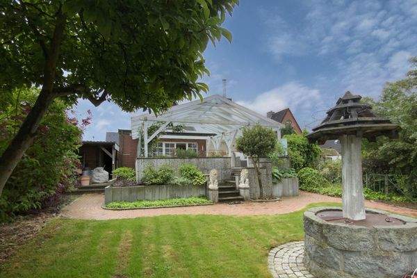 Rückseite des Hauses mit überdachter Terrasse im Sommer