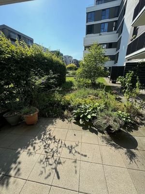 Blick von der Terrasse in den grünen Innenhof