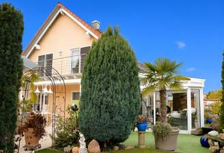 Peachfarbenes Haus mit Garten und Terrasse.png