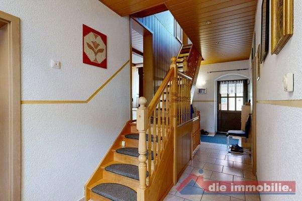 Heller Eingangsbereich mit Holztreppe und traditionellem Charme