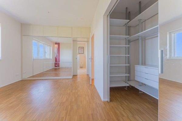 Master-Schlafzimmer mit begehbarem Schrank und Zugang zum Badezimmer