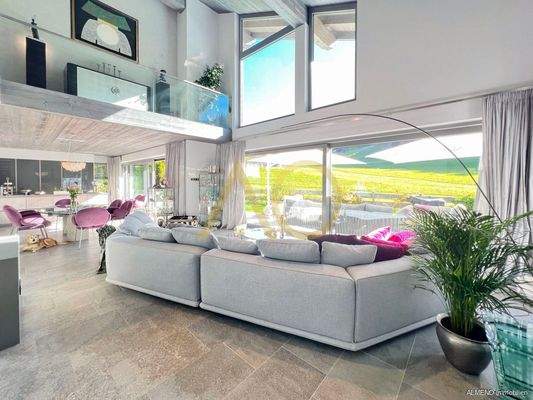 Offenes Wohnzimmer mit viel Glas zum Garten