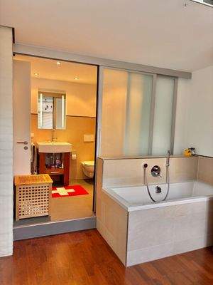 Das Ankleidezimmer mit Glaswand zum Bad