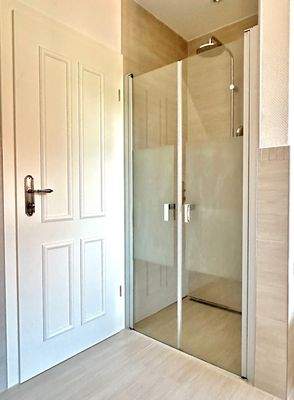 Großzügiger Duschbereich mit Glastür im Vollbad