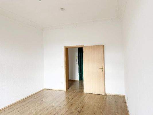 Schlafzimmer mit Stuckdecke und Blick Richtung Flurbereich