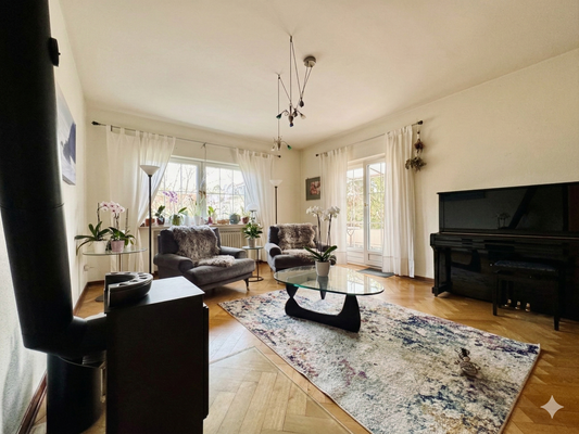 OG Wohnzimmer mit Kamin und Zugang auf den überdachten Balkon