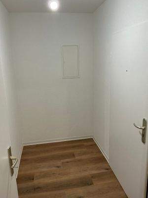 Flur mit Bodenbelag in Holzoptik, Wände weiß angelegt