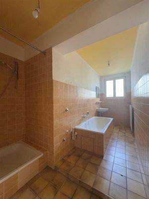 Das Bad mit Badewanne und Dusche