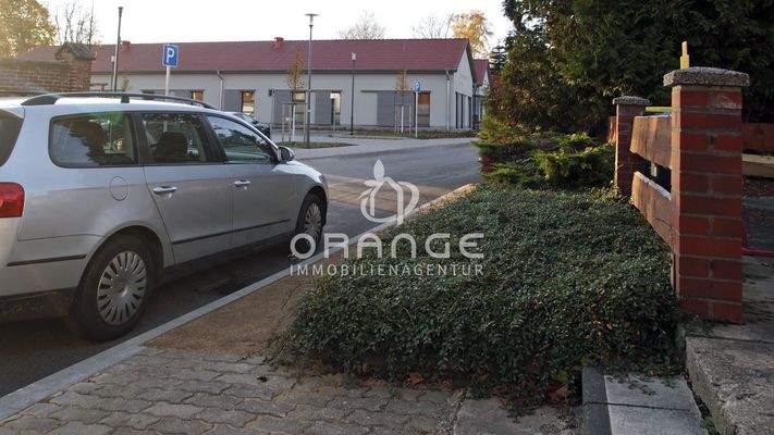 Zugang über die Terasse | im Hintergrund: Gesundheitszentrum mit Parkplatz